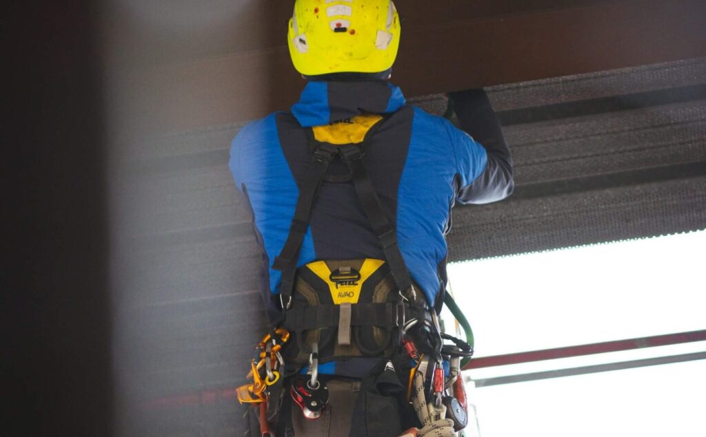 trabajador con arnes y casco de seguridad